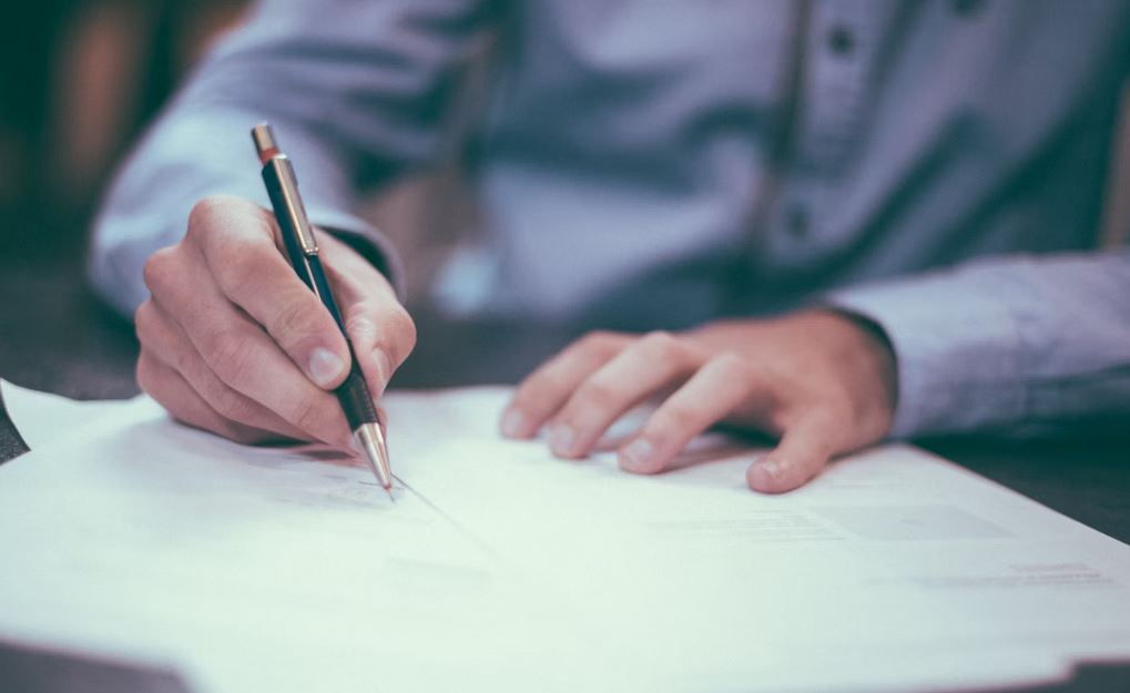 Personne rédigeant une lettre de résiliation pour un forfait mobile