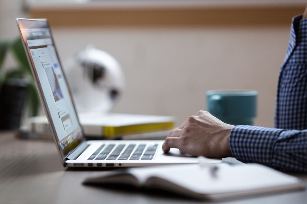 mains d'un homme désinstallant DNS Unlocker de son ordinateur portable