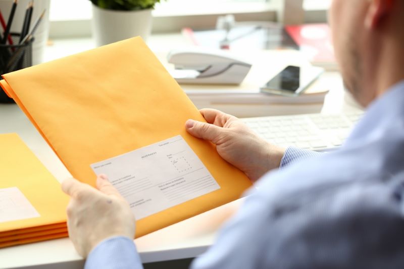 Une personne reçoit un courrier recommandé avec accusé de réception en version papier
