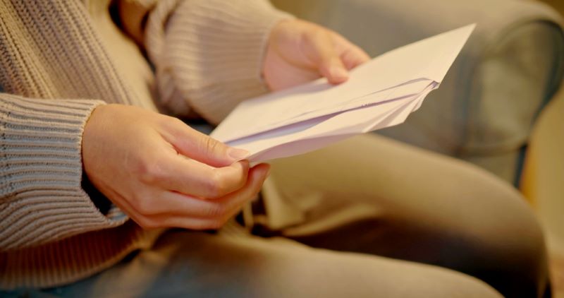 Femme ouvre sa lettre recommandée lié à une résiliation