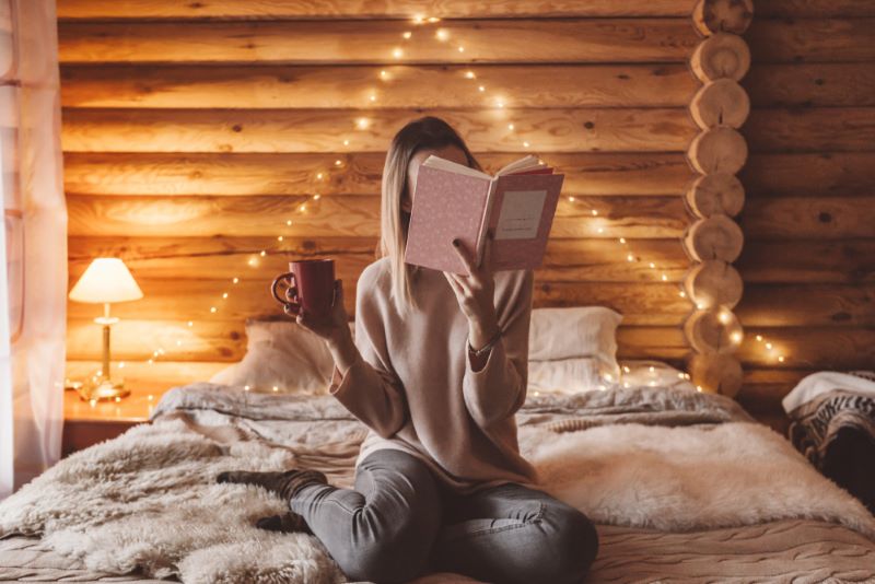 Femme qui se détend en lisant un livre sur son lit