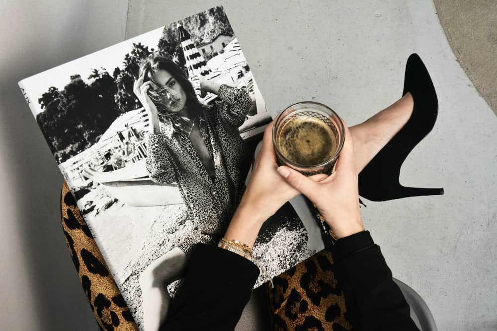 femme avec une tasse de café et un magazine Marie Claire ouvert sur ses genoux