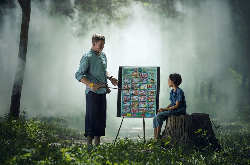 Un professeur particulier enseigne à un enfant, au milieu d'une forêt