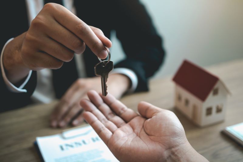 Un agent immobilier tend les clés d'un appartement à son nouveau client, locataire Foncia
