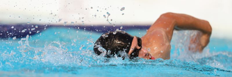 Un nageur est en train de nager en crawl dans une piscine