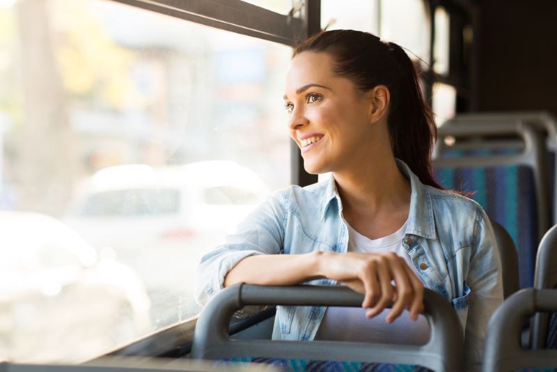 Une jeune femme regarde par la vitre pendant qu'elle est assise dans un bus Divia à Dijon
