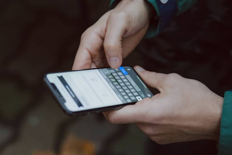 mains d'une personne utilisant l'application Yubo sur son smartphone