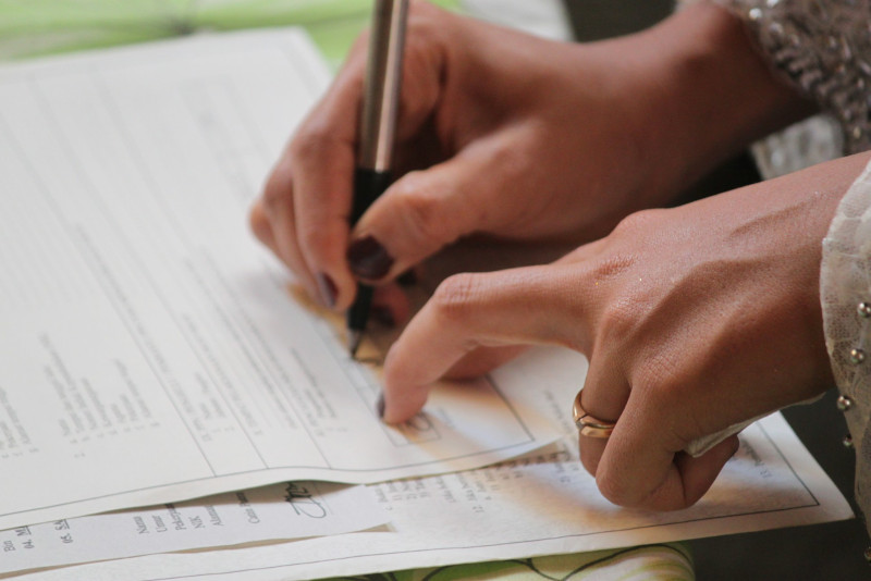 femme signant sa lettre de résiliation pour une assurance Heym