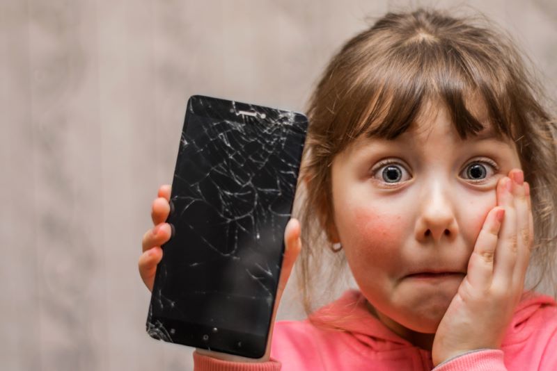 Une fillette effrayée parce qu'elle a fait tomber un smartphone et qu'il est cassé