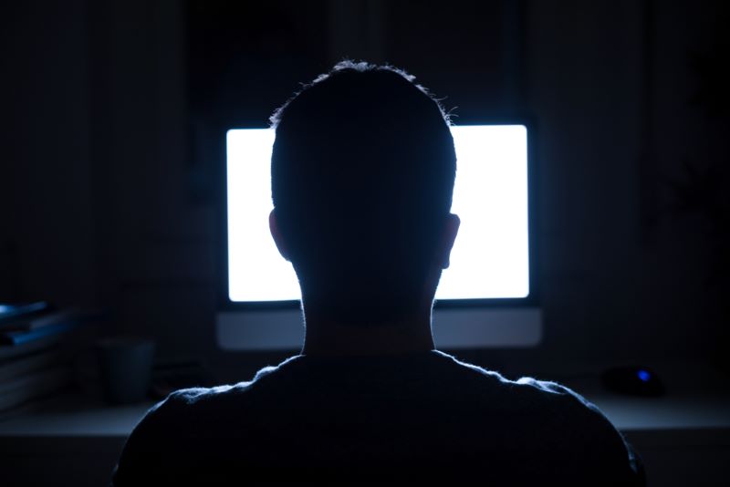 Homme devant son ordinateur qui prépare un piratage informatique