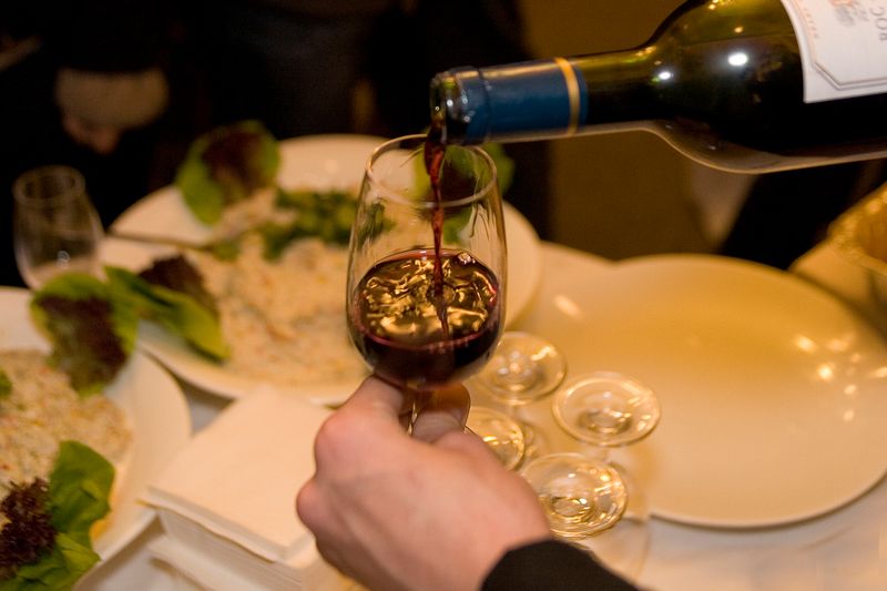 personne servant un verre de vin, avec une bouteille reçue dans une box 18h15