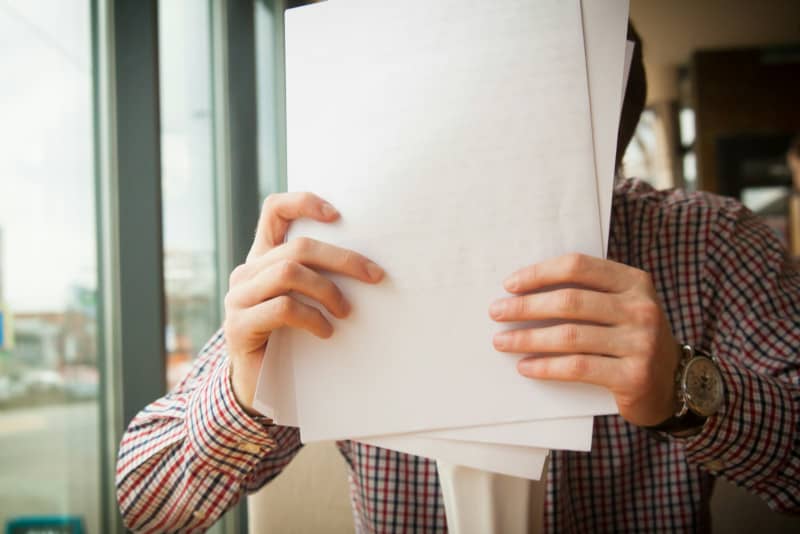 homme tenant son contrat Carrefour Assurance