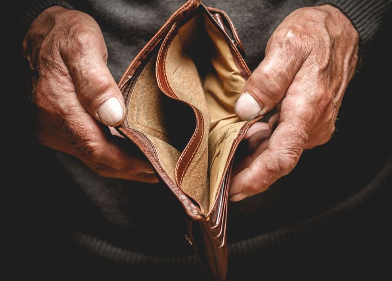 Mains qui écartent un portefeuille vide à la recherche d'argent