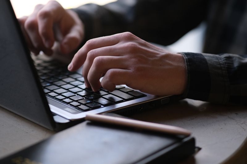 mains d'un homme fermant son compte Viva.com depuis un ordinateur portable
