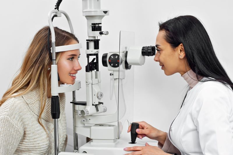 Un ophtalmologue examine les yeux de sa patiente