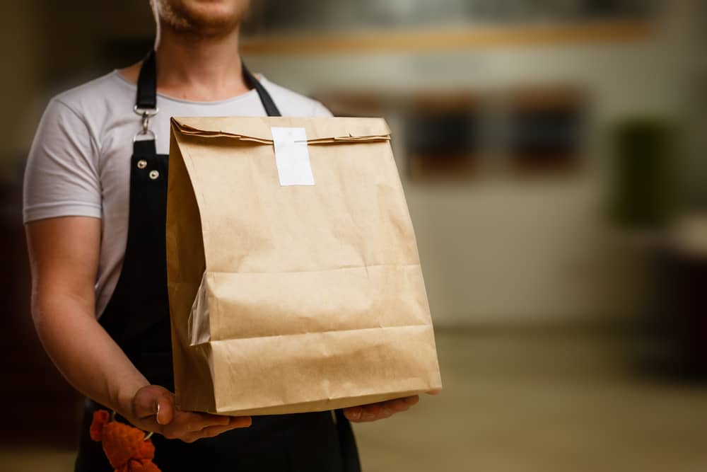 homme portant un sac de nourriture livré par Degusta Box