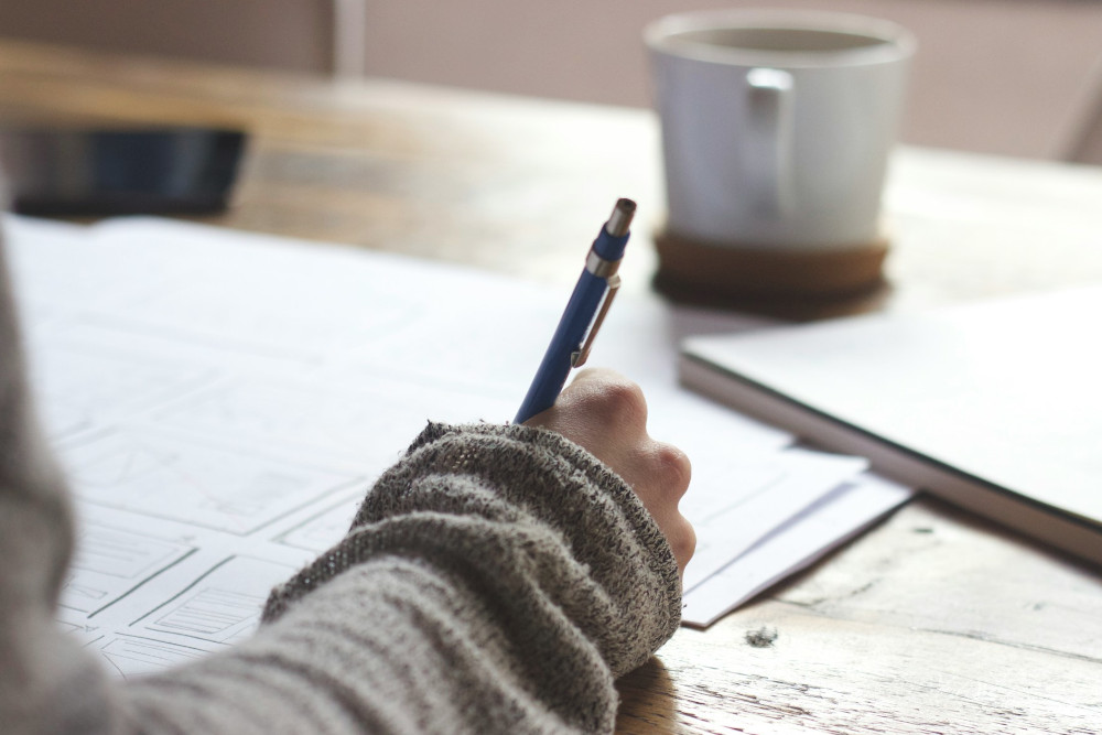 femme écrivant une lettre de résiliation pour l'assurance habitation Banque Populaire