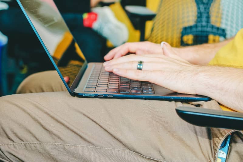mains d'un homme résiliant son abonnement Je Pilote sur son ordinateur portable