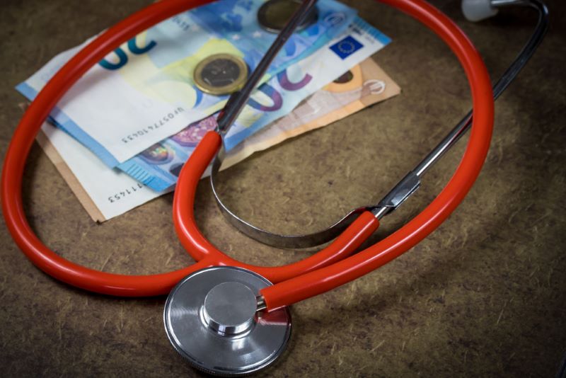 Un stéthoscope posé sur des billets de banque et une pièce, symbolisent le remboursement des frais de santé par une mutuelle