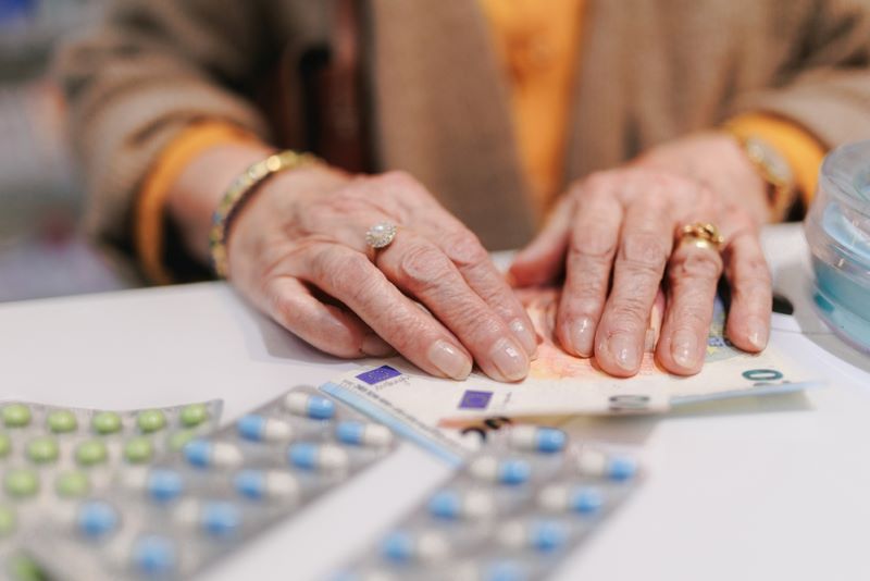 Femme âgée qui paie ses médicaments qui ne sont pas remboursés