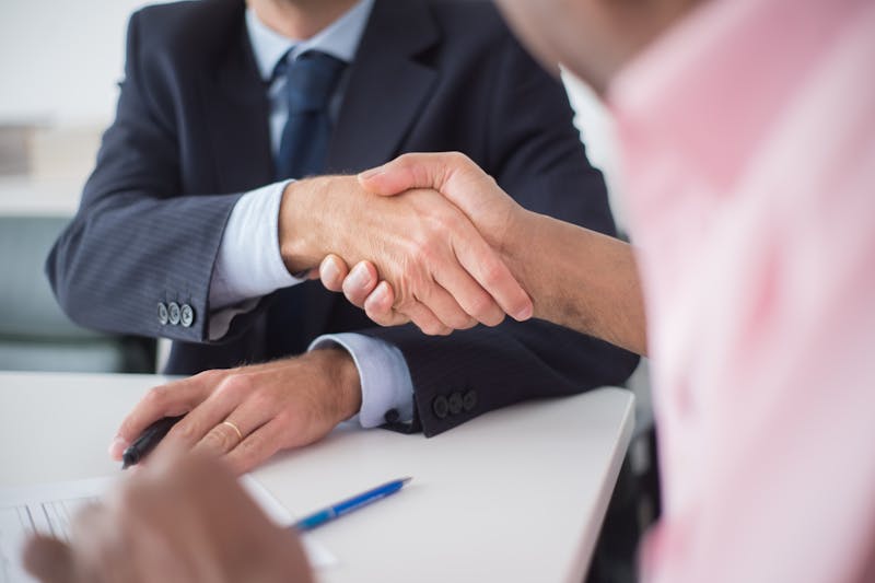 assuré et conseiller se serrant la main après la résiliation d'un contrat Tutélaire