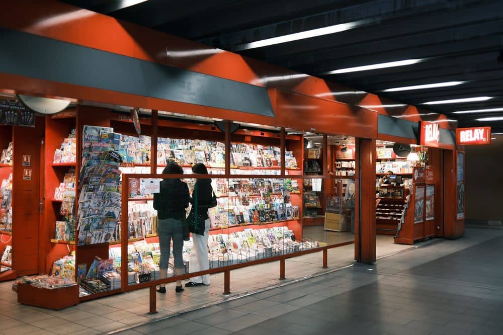 deux femmes regardent les magazines So Foot dans un kiosque à journaux