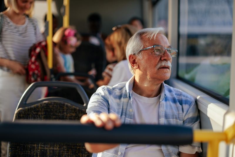 Un vieux monsieur est assis dans le bus et voyage sur les lignes Tisseo Toulouse