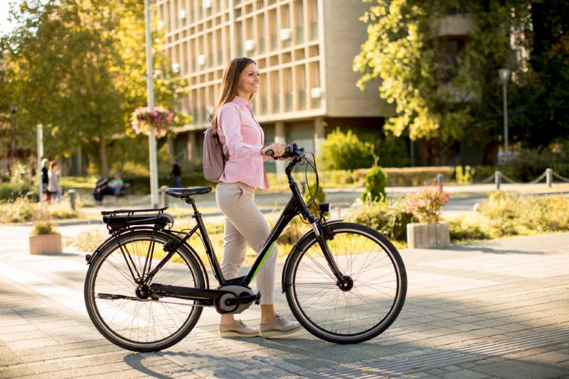Une jeune femme traverse Avignon avec son vélo Velopop'